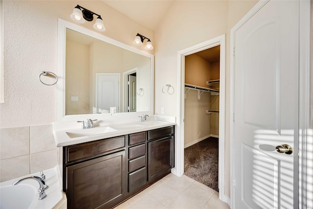 bathroom with tile patterned floors, vanity, and a bath