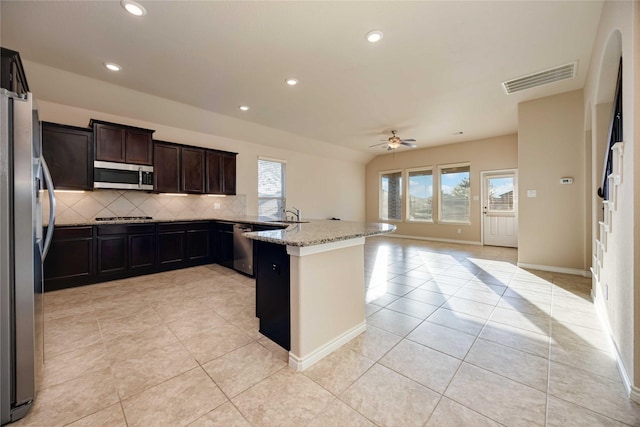 kitchen with decorative backsplash, ceiling fan, light stone countertops, light tile patterned flooring, and stainless steel appliances