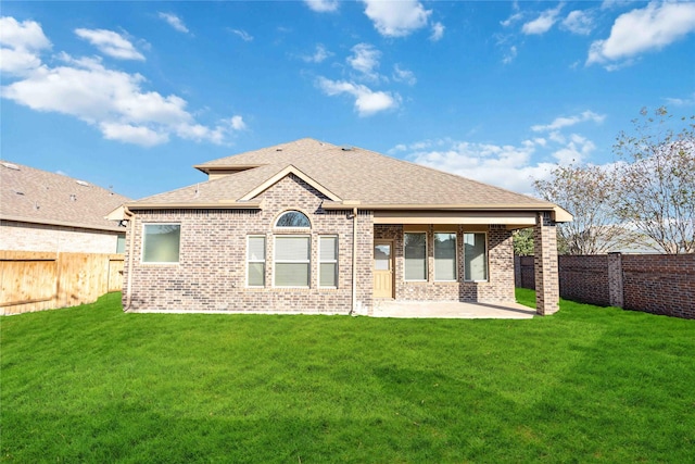 rear view of property with a yard and a patio area