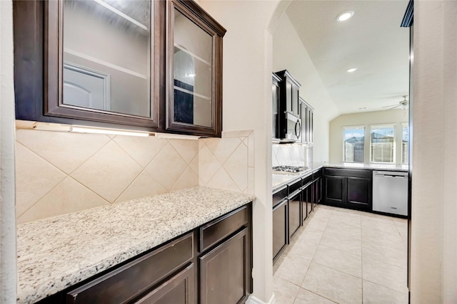 kitchen featuring lofted ceiling, ceiling fan, decorative backsplash, dark brown cabinets, and stainless steel appliances