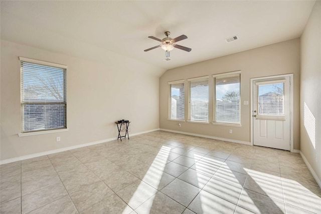 spare room featuring ceiling fan, light tile patterned floors, a wealth of natural light, and vaulted ceiling