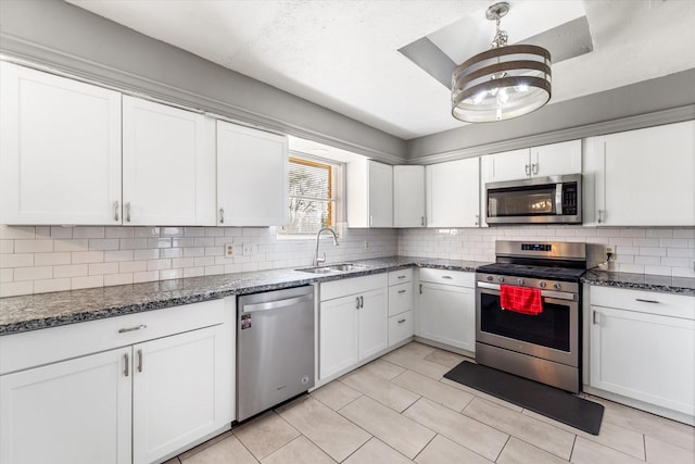 kitchen with decorative backsplash, sink, white cabinetry, and stainless steel appliances