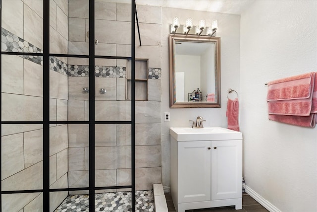 bathroom with vanity and tiled shower