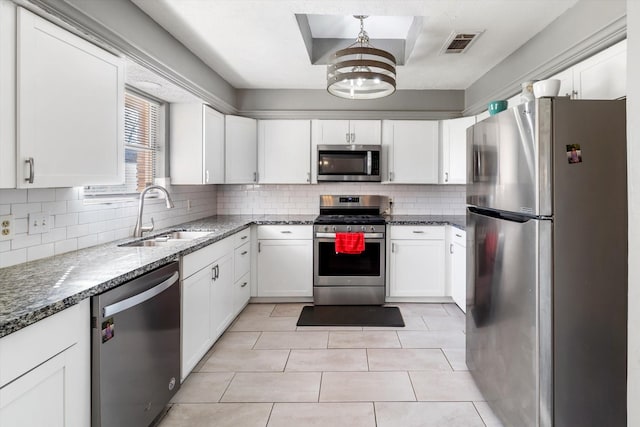 kitchen with appliances with stainless steel finishes, backsplash, white cabinetry, and sink