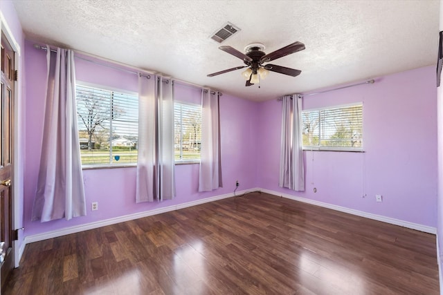 empty room with a textured ceiling, dark hardwood / wood-style flooring, and ceiling fan