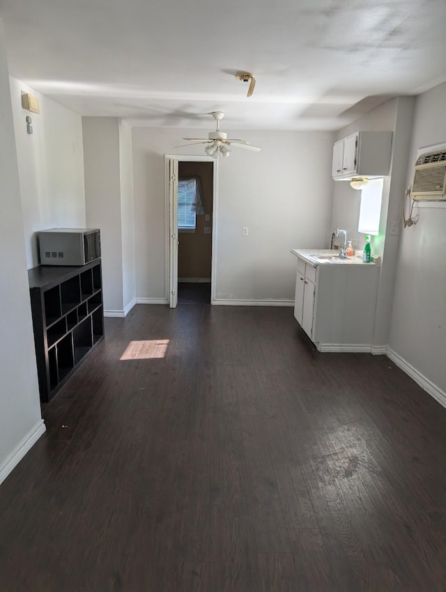 interior space featuring ceiling fan, sink, white cabinets, and dark wood-type flooring