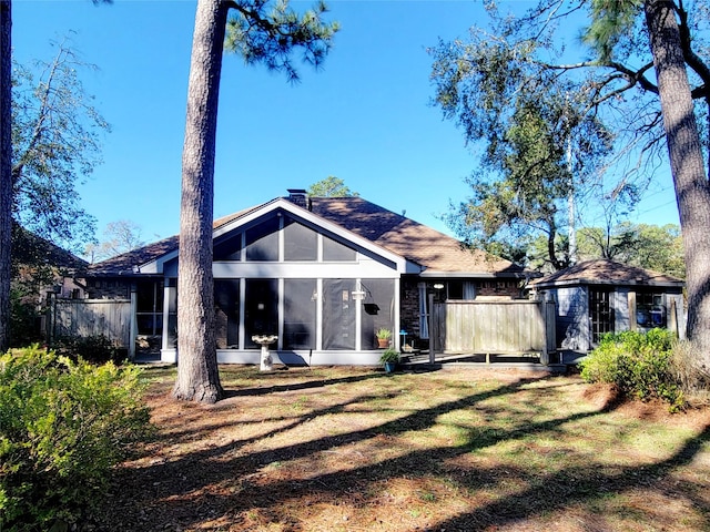 back of house with a lawn and a sunroom