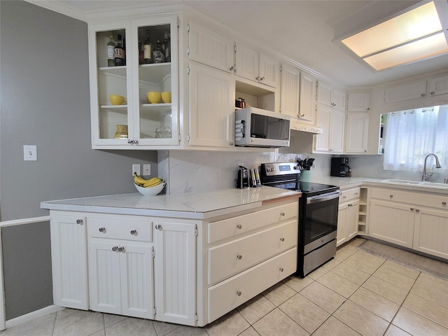 kitchen featuring white cabinets, light tile patterned floors, stainless steel range with electric stovetop, and sink