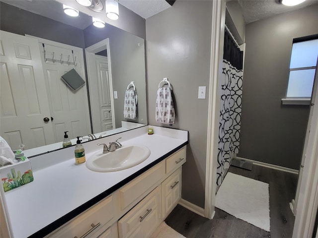 bathroom featuring a textured ceiling, vanity, hardwood / wood-style flooring, and a shower with curtain