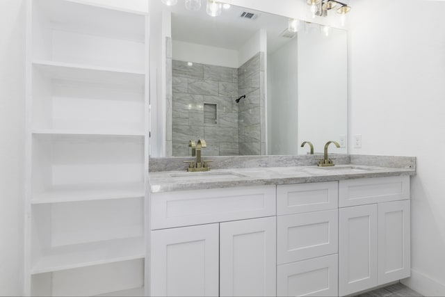 bathroom with vanity and tiled shower