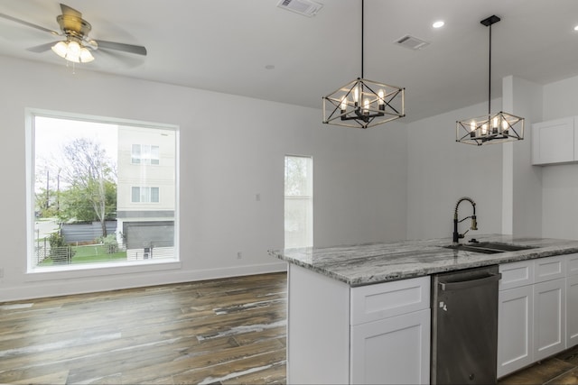 kitchen with light stone counters, stainless steel dishwasher, ceiling fan with notable chandelier, pendant lighting, and white cabinets