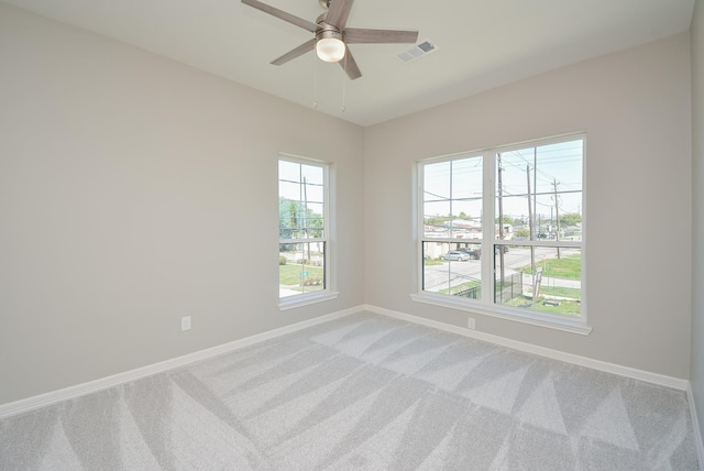 carpeted empty room featuring a wealth of natural light and ceiling fan