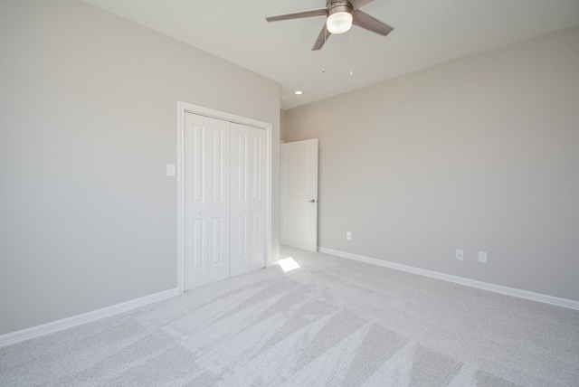 unfurnished bedroom featuring light carpet, a closet, and ceiling fan