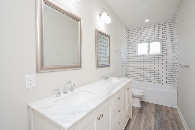 full bathroom with wood-type flooring, vanity, toilet, and tiled shower / bath