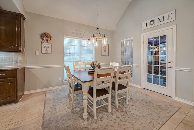 tiled dining space featuring vaulted ceiling and a notable chandelier