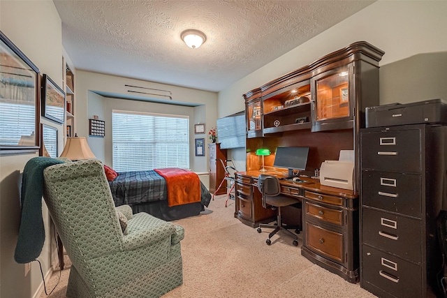 bedroom with a textured ceiling and light colored carpet