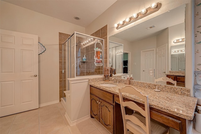 bathroom with tile patterned flooring, vanity, and walk in shower