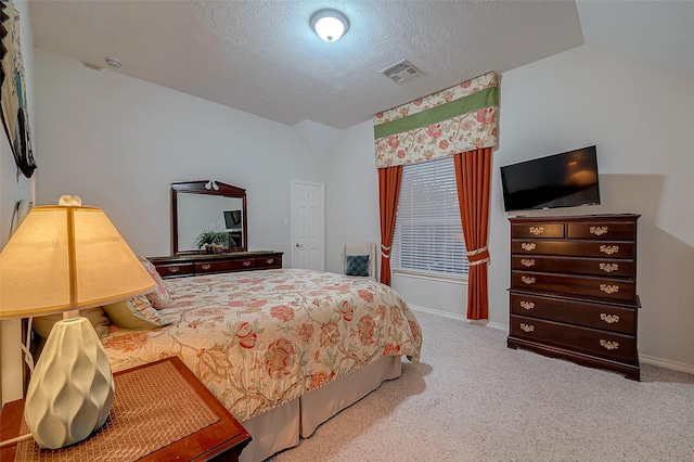 bedroom with light carpet and a textured ceiling