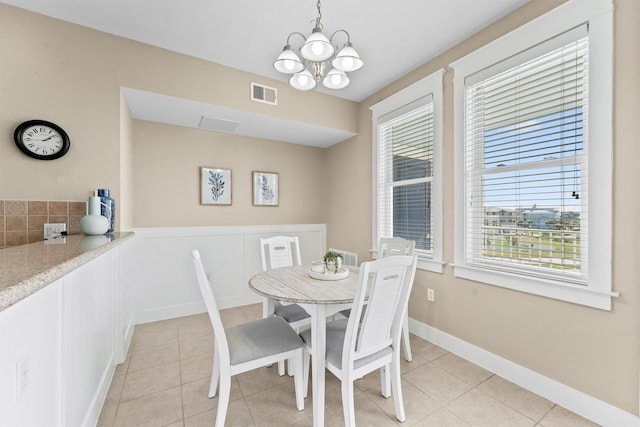 dining area with a chandelier and light tile patterned flooring