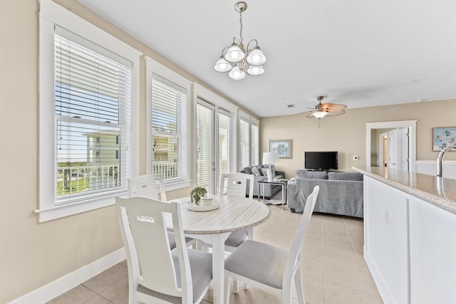 tiled dining area with ceiling fan with notable chandelier