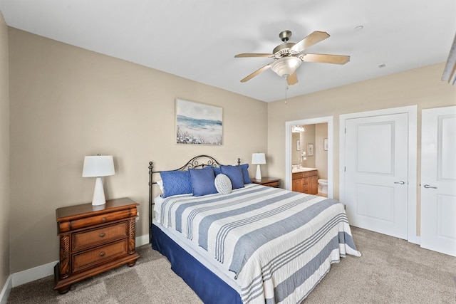 carpeted bedroom with ceiling fan and connected bathroom