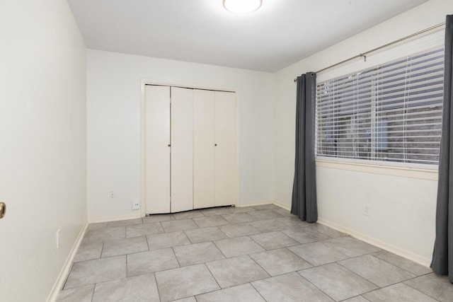 unfurnished bedroom featuring light tile patterned floors and a closet