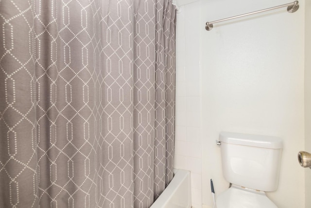 bathroom featuring toilet and shower / bathtub combination with curtain