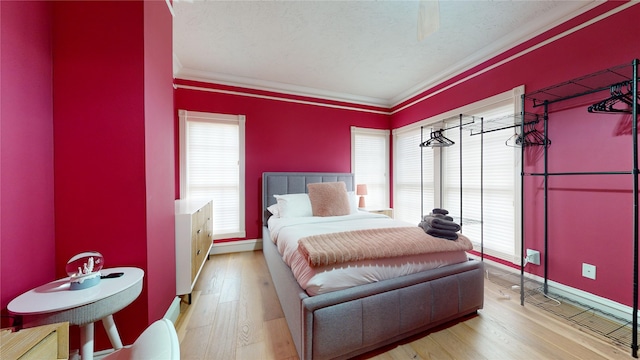 bedroom with light hardwood / wood-style floors and ornamental molding