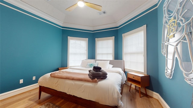 bedroom with hardwood / wood-style floors, ceiling fan, and crown molding