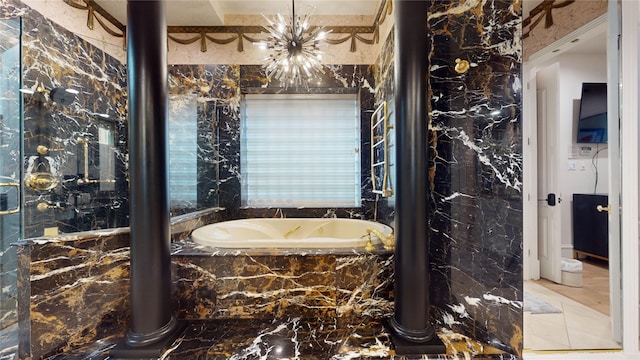 bathroom featuring a notable chandelier and tiled tub