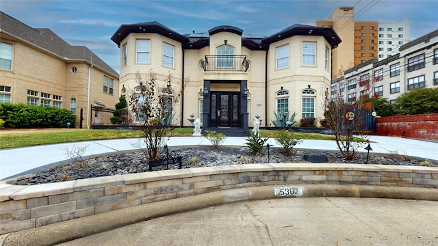 view of front of house with a balcony and french doors