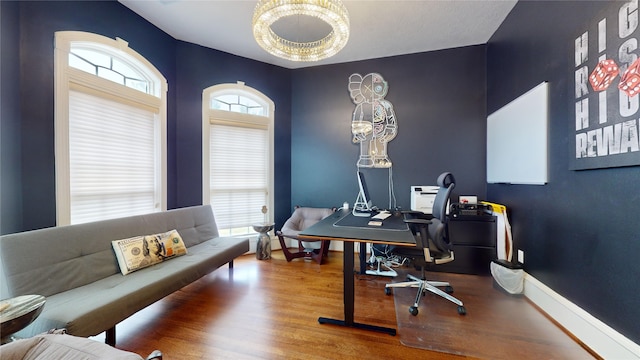 office with hardwood / wood-style flooring and an inviting chandelier