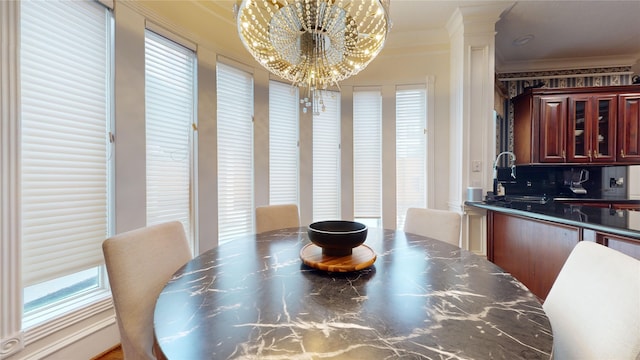 dining area with ornate columns, ornamental molding, and a chandelier