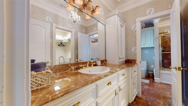 bathroom with vanity, toilet, and ornamental molding