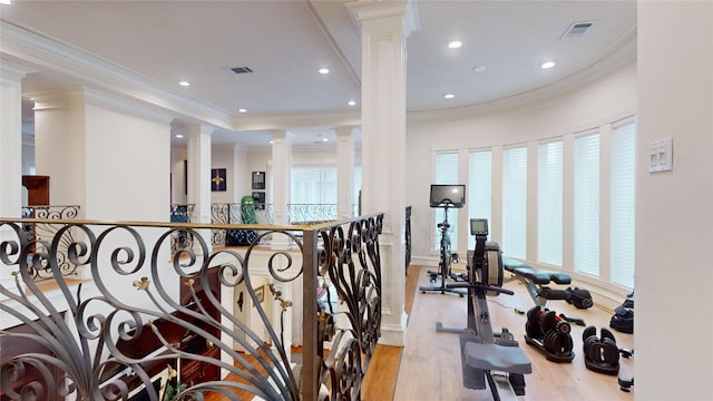 workout area featuring light hardwood / wood-style flooring and ornamental molding