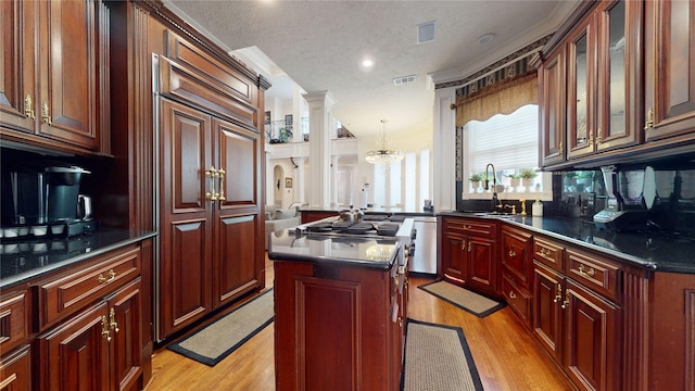 kitchen featuring dishwasher, a center island, sink, hanging light fixtures, and a textured ceiling