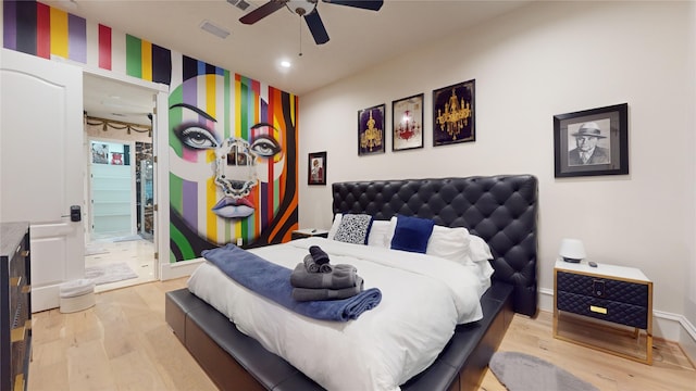 bedroom featuring ceiling fan, ensuite bathroom, and light wood-type flooring