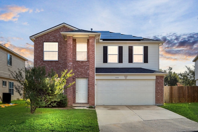 view of front property with solar panels, a yard, and a garage