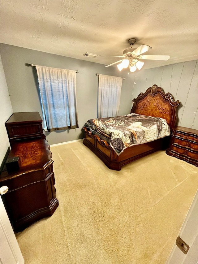 carpeted bedroom featuring a textured ceiling and ceiling fan