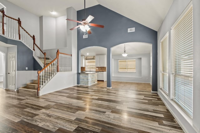 unfurnished living room featuring hardwood / wood-style flooring, high vaulted ceiling, and ceiling fan