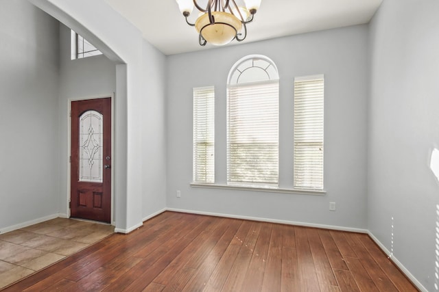 entryway with dark wood-type flooring and a notable chandelier