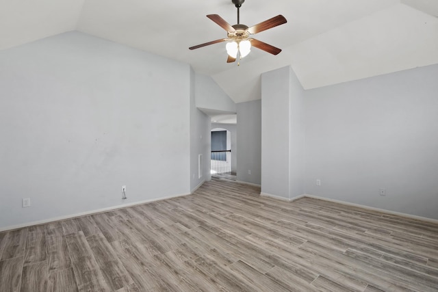 spare room with ceiling fan, light hardwood / wood-style floors, and vaulted ceiling