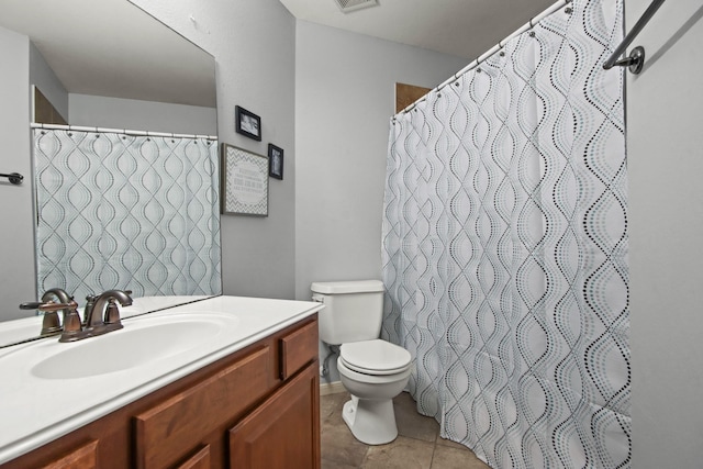 bathroom with tile patterned flooring, vanity, and toilet