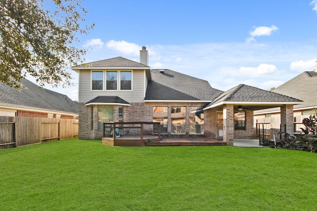 rear view of house with a deck and a lawn