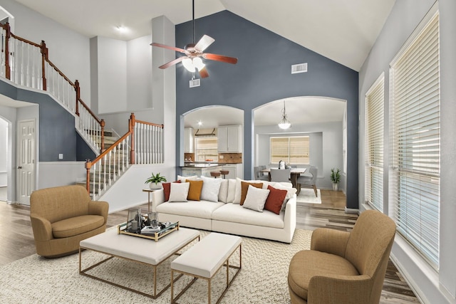 living room with hardwood / wood-style flooring, high vaulted ceiling, and ceiling fan