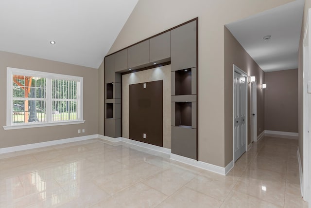 kitchen with gray cabinets, lofted ceiling, and light tile patterned flooring