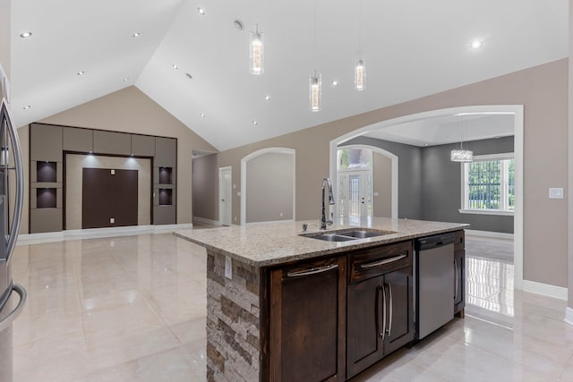 kitchen with pendant lighting, sink, light stone counters, stainless steel dishwasher, and a center island with sink