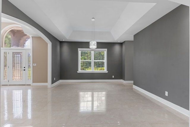 unfurnished dining area featuring a raised ceiling