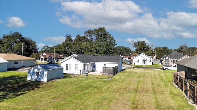 exterior space featuring an outbuilding, a storage unit, fence, and a residential view