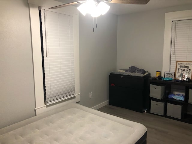 bedroom with ceiling fan, baseboards, and wood finished floors